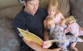 Un padre lee a sus hijos