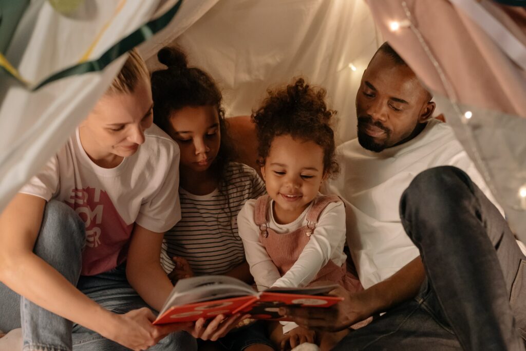Familia leyendo bajo una manta 