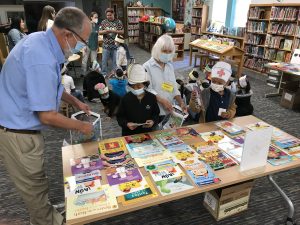 Volunteers at Wooten Elementary help students choose Summer Success books.