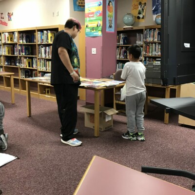 Program Associate Alex helps a student choose his Summer Success books.